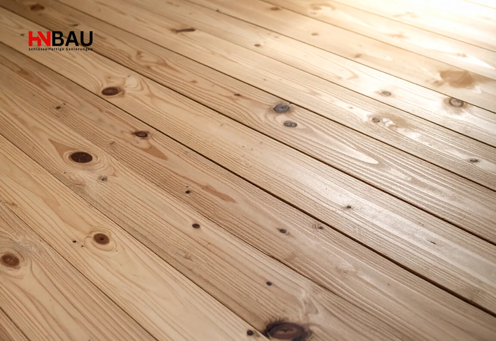 Neu verlegte Holzdielen mit sichtbarer Maserung und natürlicher Knotenstruktur; warmer und hochwertiger Holzfußboden.