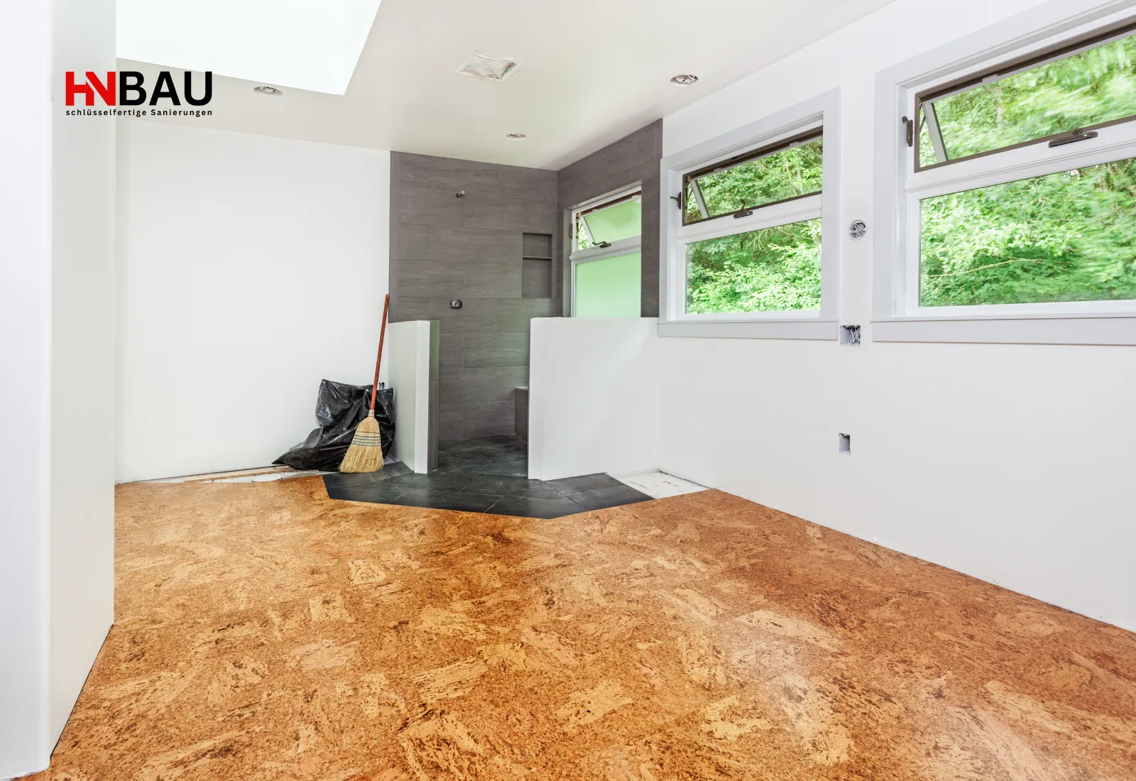 Neu verlegter Korkboden in einem renovierten Raum mit großen Fenstern und angrenzendem gefliesten Nassbereich; natürlicher und warmer Bodenbelag.